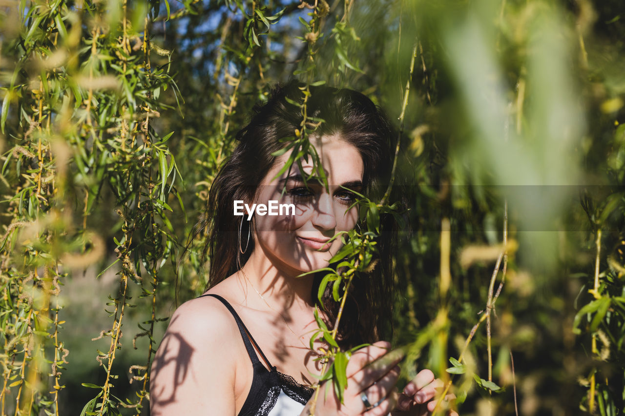 Portrait of young woman amidst plants