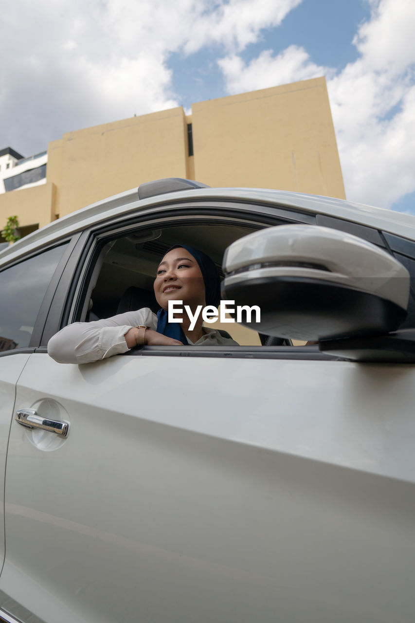 Woman smiling while sitting in car