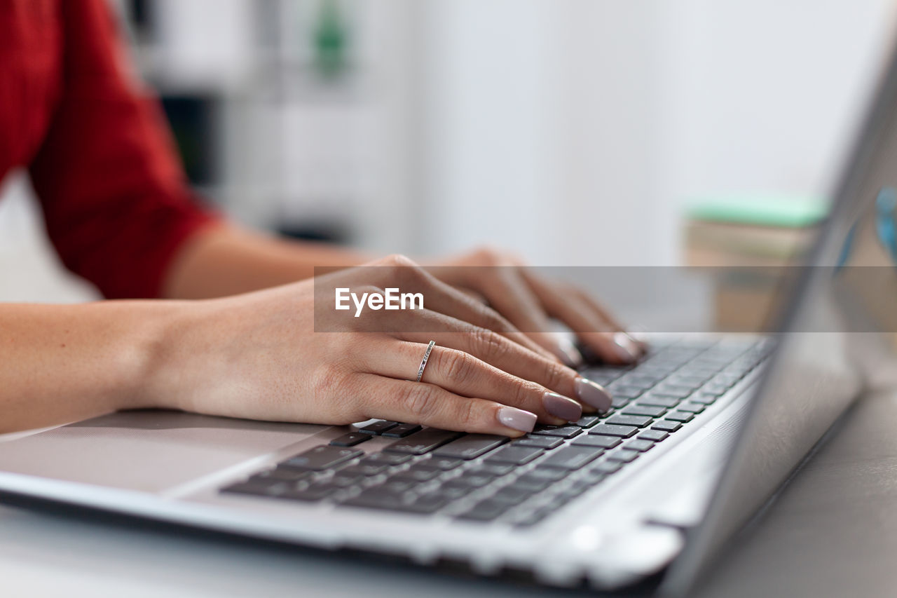 Midsection of businesswoman working on laptop