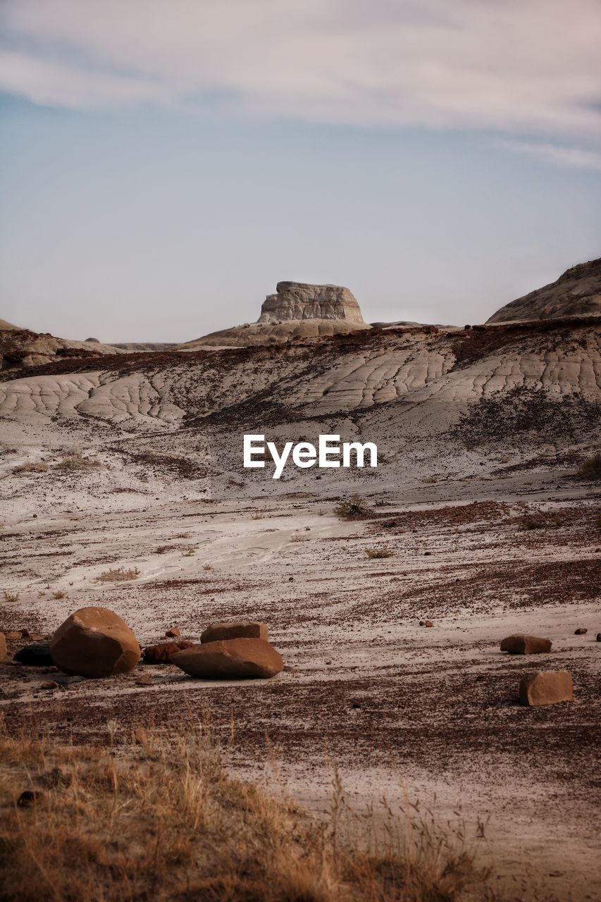 SCENIC VIEW OF ROCKS ON LAND AGAINST SKY