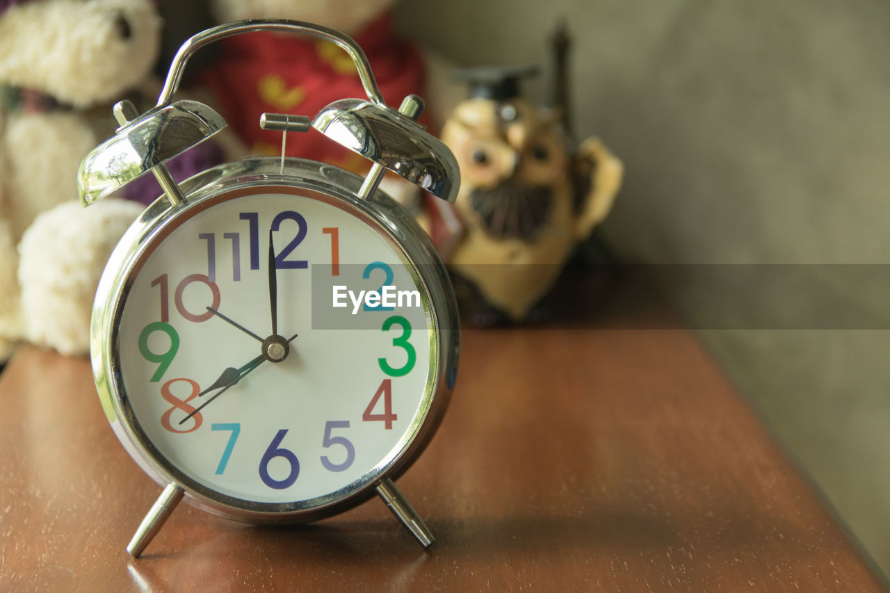 CLOSE-UP OF CLOCK ON TABLE AT HOME