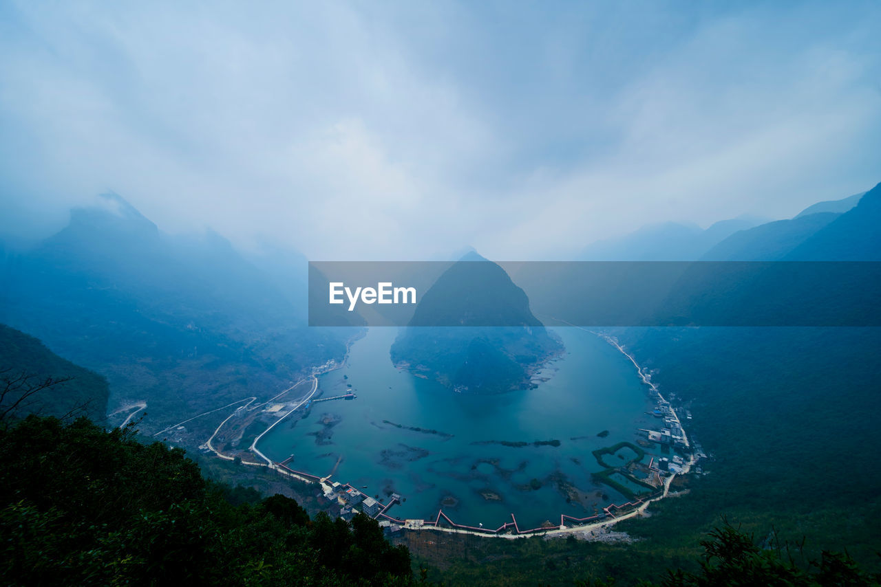 High angle view of lake amidst mountains against sky