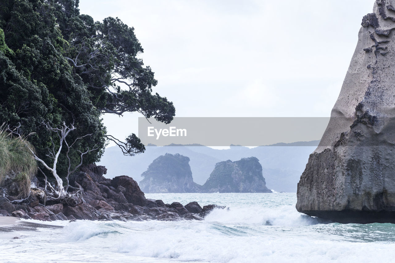 Rock formation by sea against sky