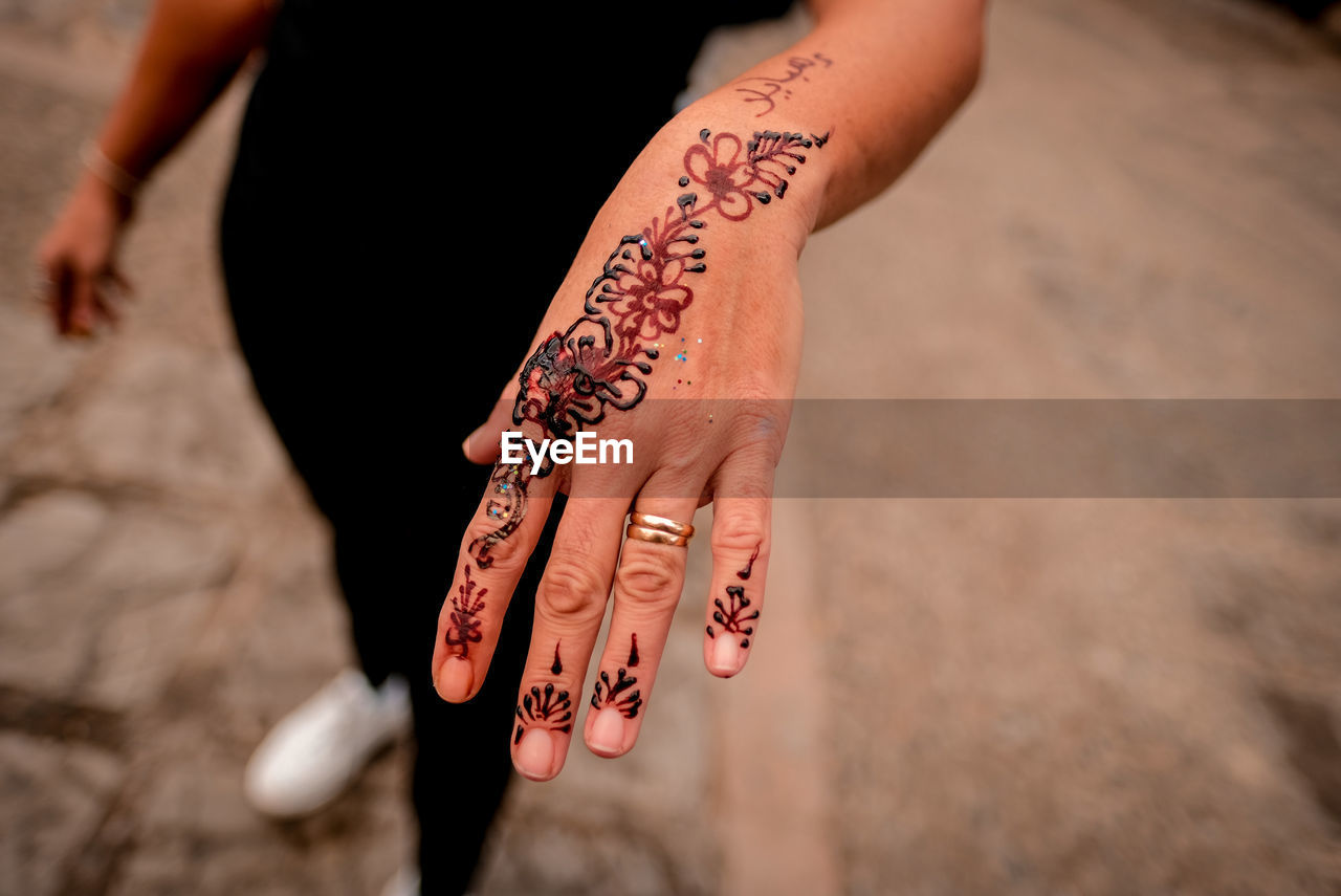 High angle view of woman hand with tattoo