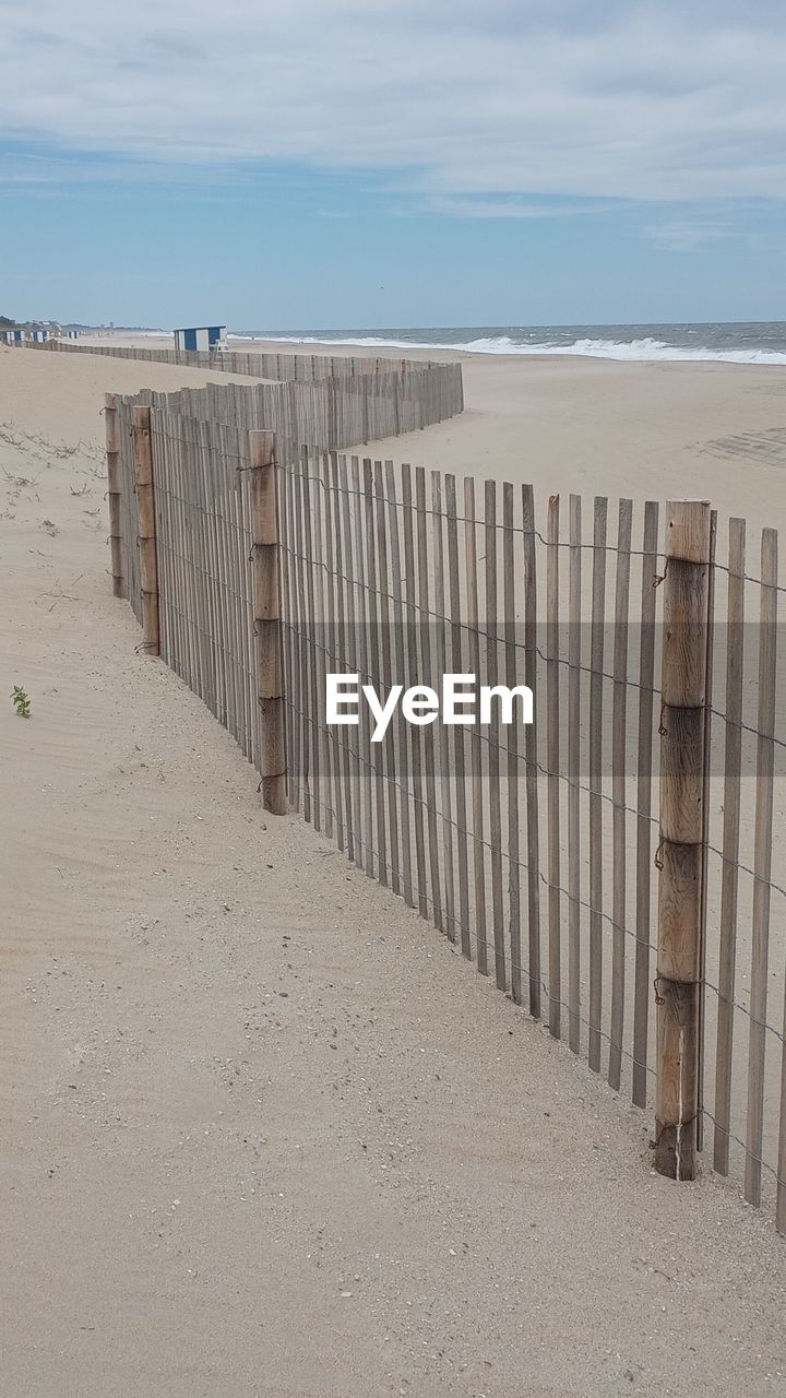 wall, architecture, built structure, wood, day, building exterior, no people, beach, nature, outdoors, roof, water, sky, white, building, sand, blue, sea, facade, land, low angle view, floor, staircase, line