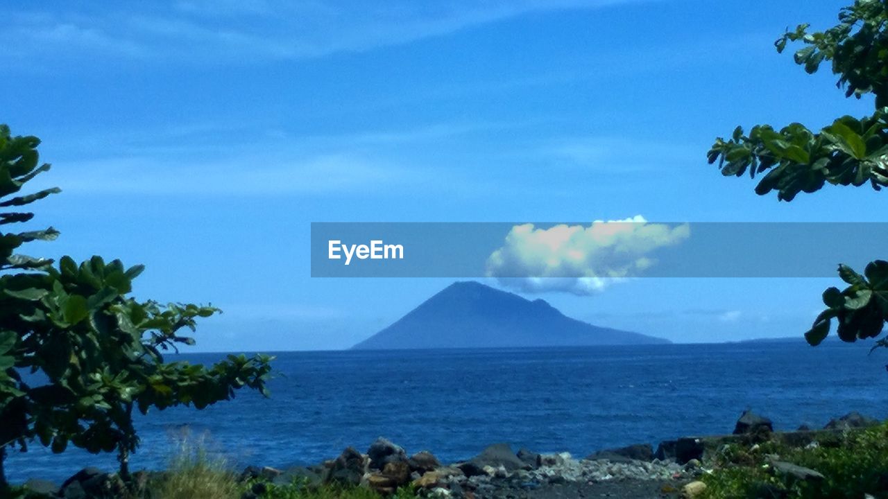 SCENIC VIEW OF SEA WITH MOUNTAIN IN BACKGROUND