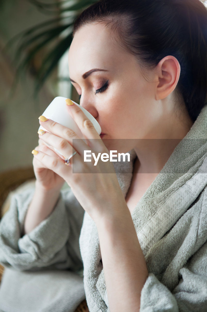 Midsection of woman drinking coffee