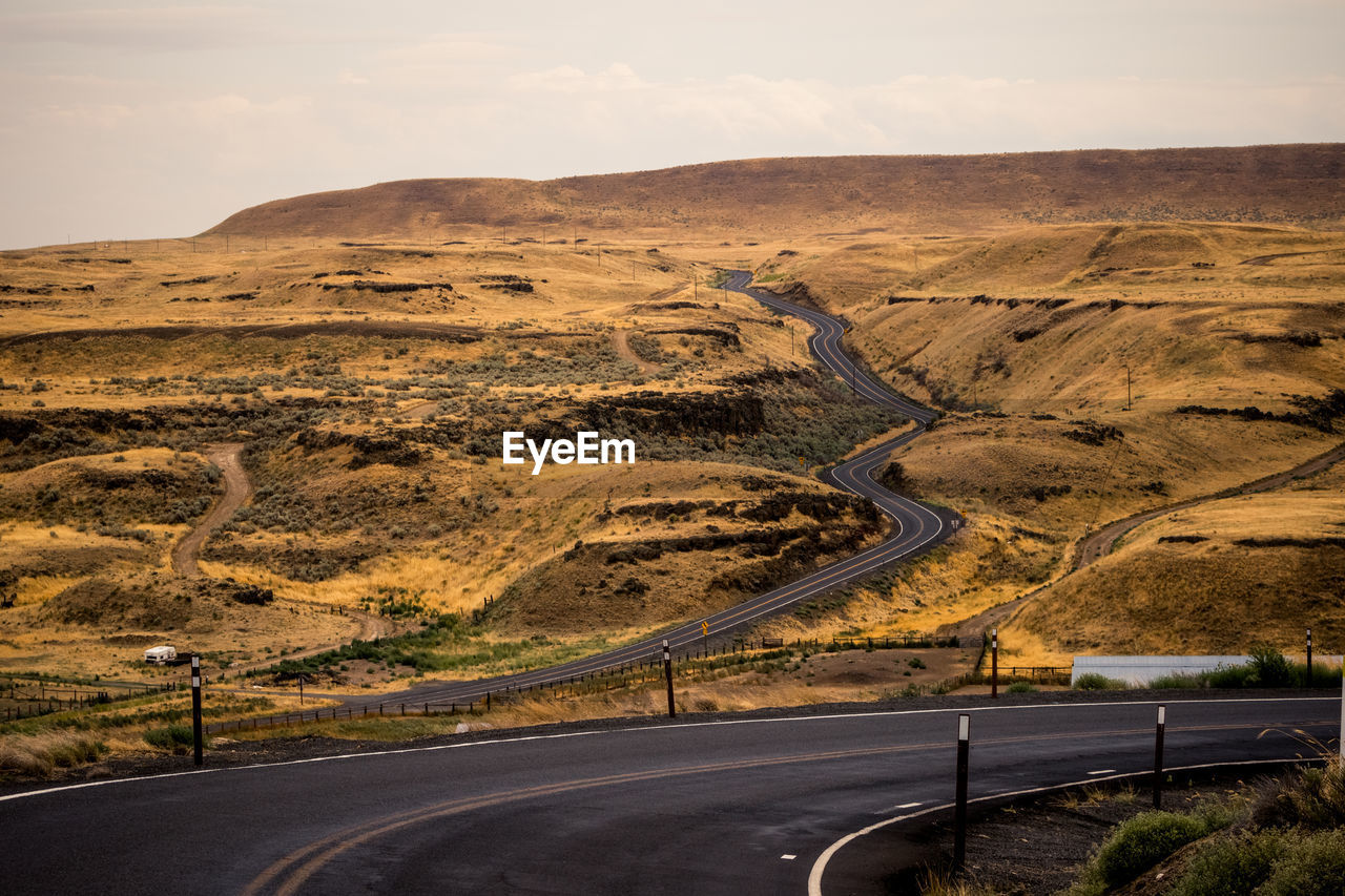 EMPTY ROAD BY MOUNTAIN AGAINST SKY