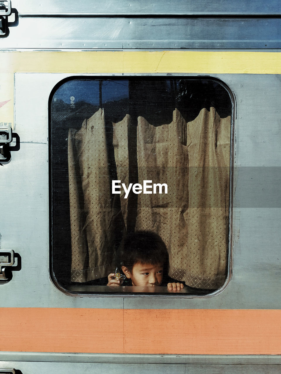 Boy looking away through train window