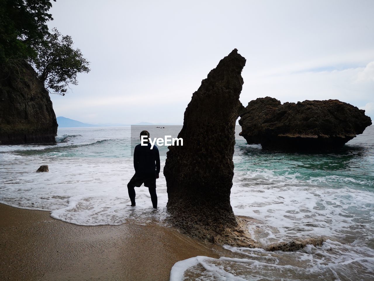 Man standing at sea against sky