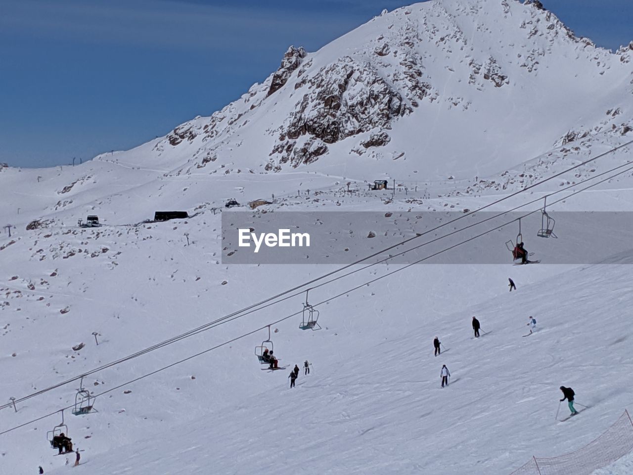 PEOPLE SKIING ON SNOW COVERED MOUNTAINS
