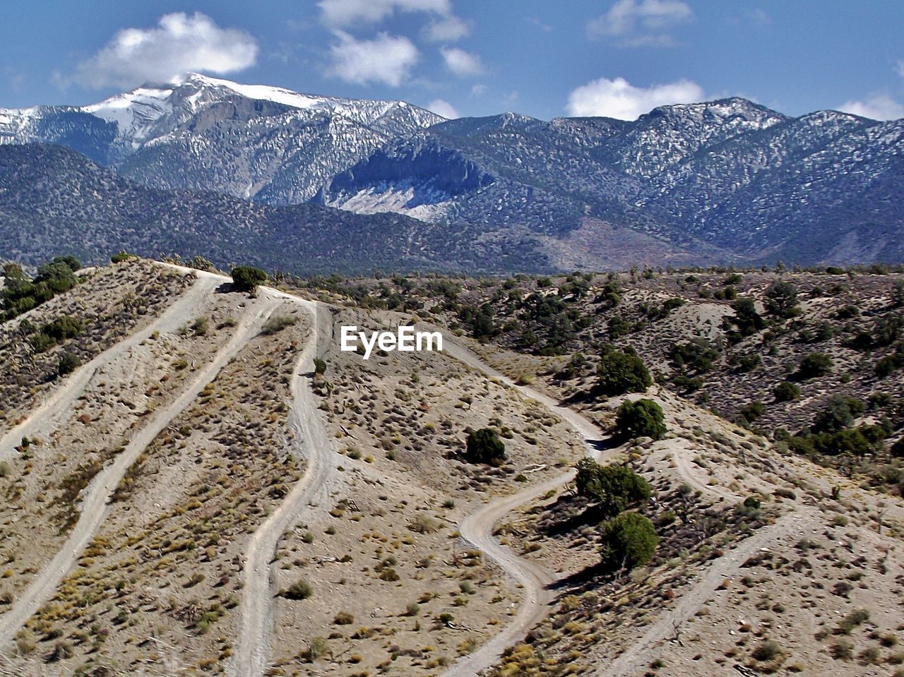 Scenic view of mountain range against cloudy sky