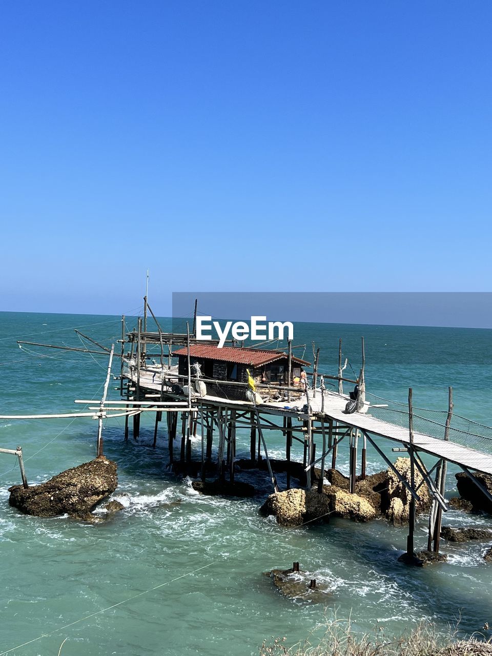 water, blue, nautical vessel, nature, day, sea, vehicle, transportation, mast, reflection, outdoors, sky, mode of transportation, men, copy space, high angle view, clear sky, sunlight, ship, architecture