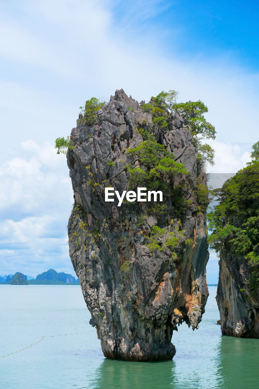 Rock formation in sea against sky