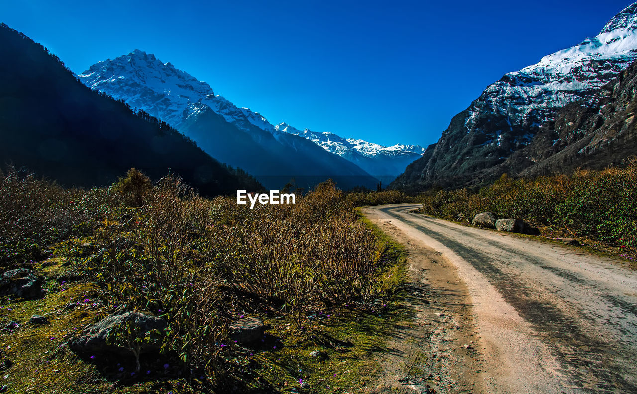 Panoramic view of snowcapped mountains against blue sky