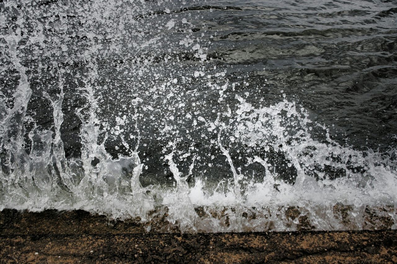 Wave splashing on rock at shore