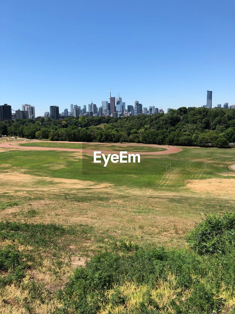 SCENIC VIEW OF FIELD AGAINST SKY IN CITY