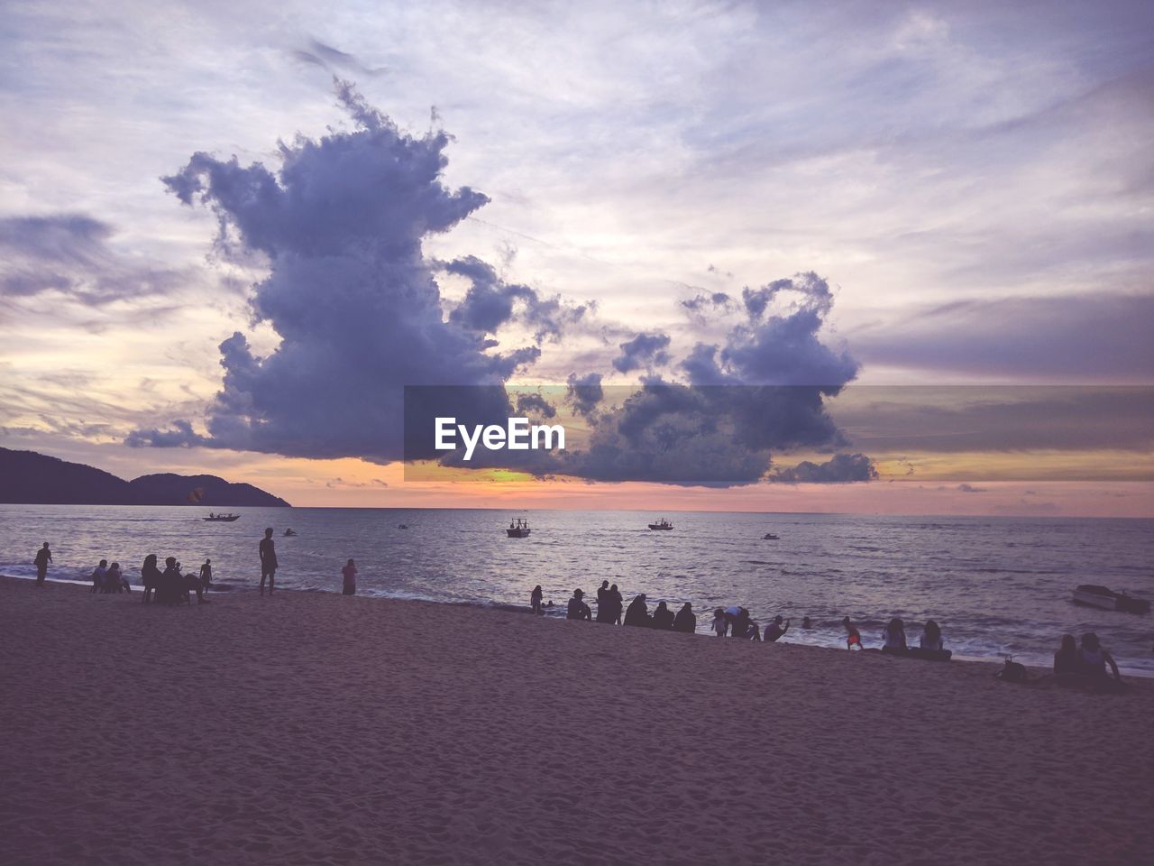 PANORAMIC VIEW OF PEOPLE ON BEACH AGAINST SKY