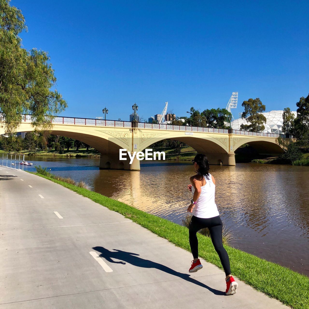 FULL LENGTH OF WOMAN STANDING ON BRIDGE OVER RIVER AGAINST CLEAR SKY