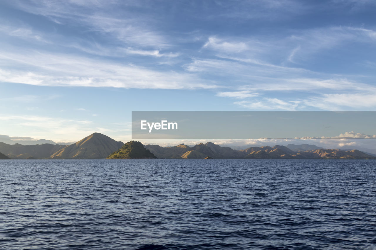 SCENIC VIEW OF SEA BY MOUNTAIN AGAINST SKY