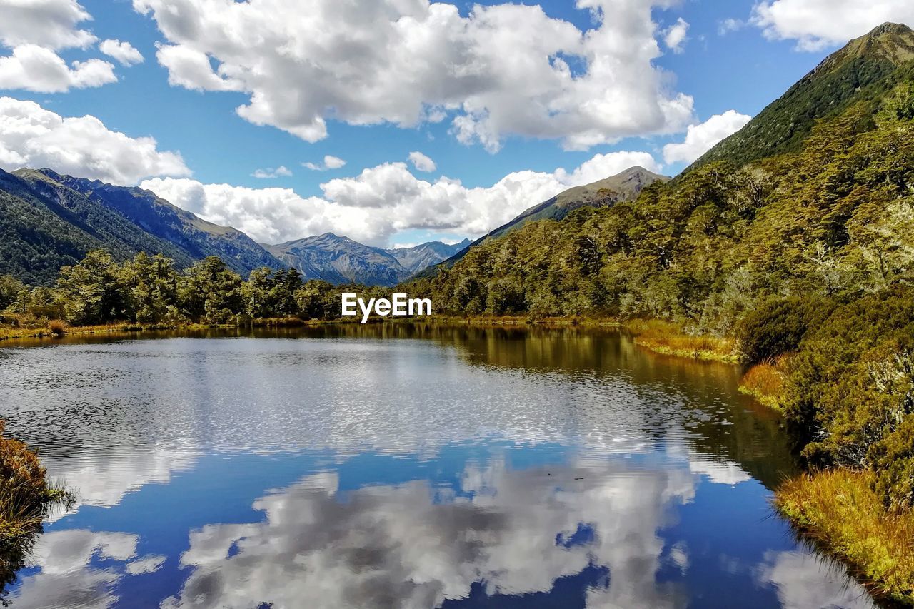 Scenic view of sky reflected in lake surrounded by mountains