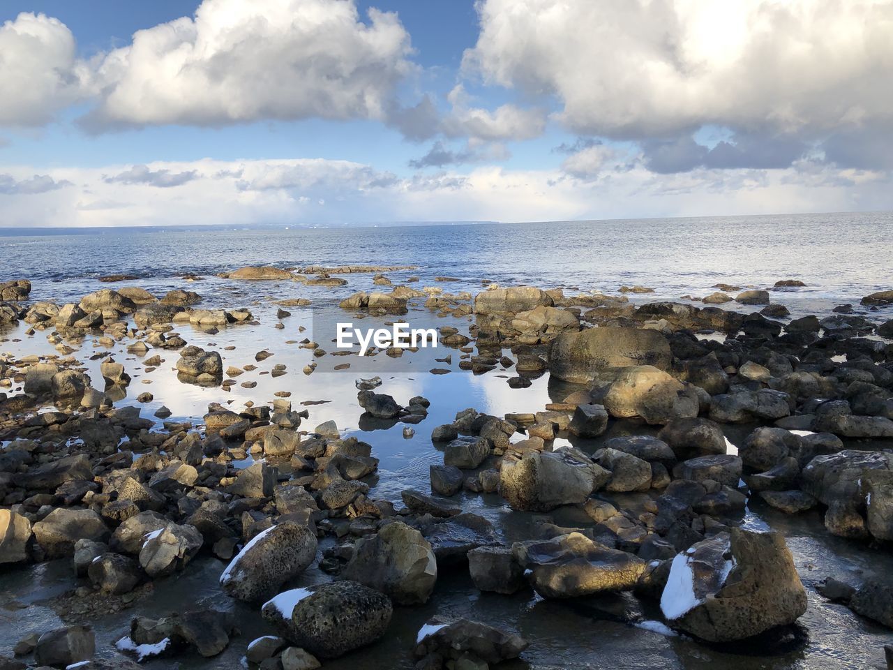 Rocks in sea against sky