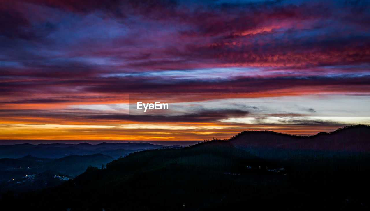 Scenic view of silhouette mountains against sky at sunset