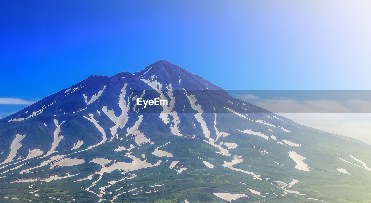 mountain, sky, mountain range, landscape, environment, scenics - nature, beauty in nature, nature, snow, ridge, mountain peak, cold temperature, winter, no people, travel destinations, land, blue, snowcapped mountain, stratovolcano, travel, non-urban scene, volcano, tranquility, tranquil scene, outdoors, cloud, summit, plateau, day, sunlight, idyllic, tourism, geology, physical geography