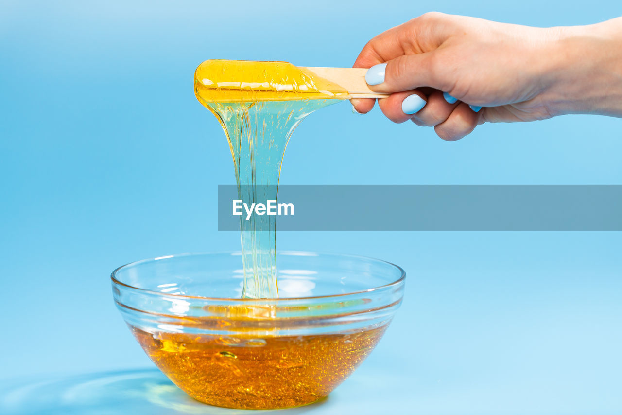 CLOSE-UP OF PERSON HAND POURING DRINK