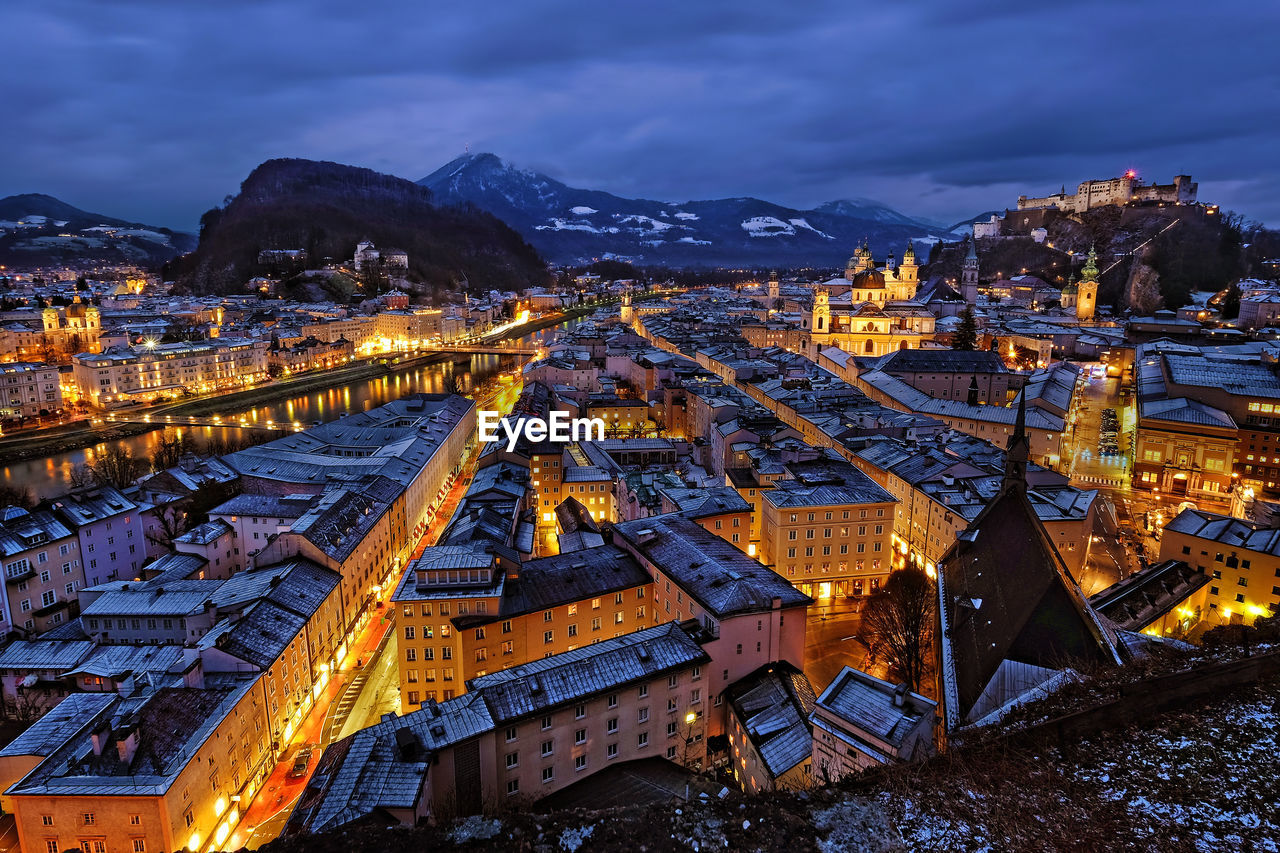 Aerial view of illuminated city against sky at dusk