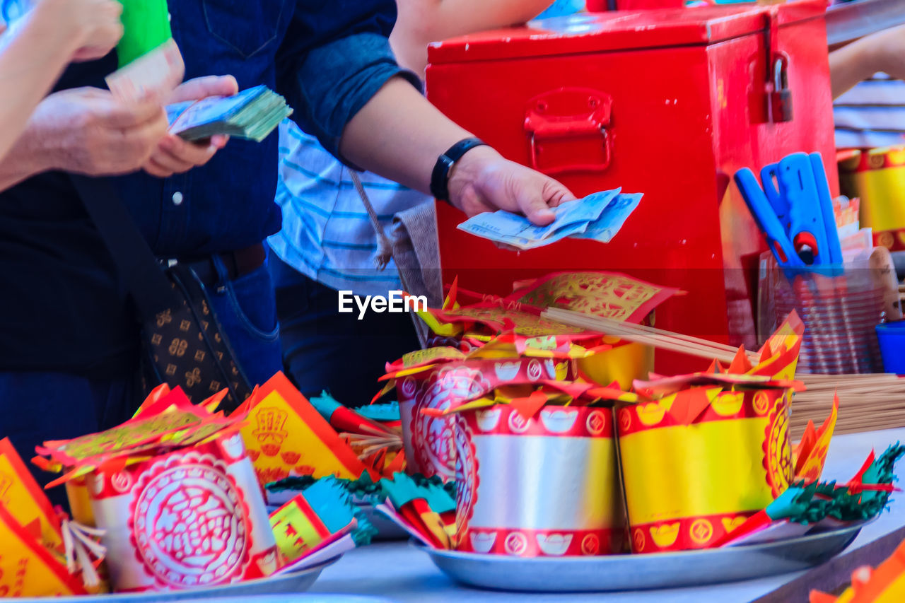 People buying religious offerings in plate