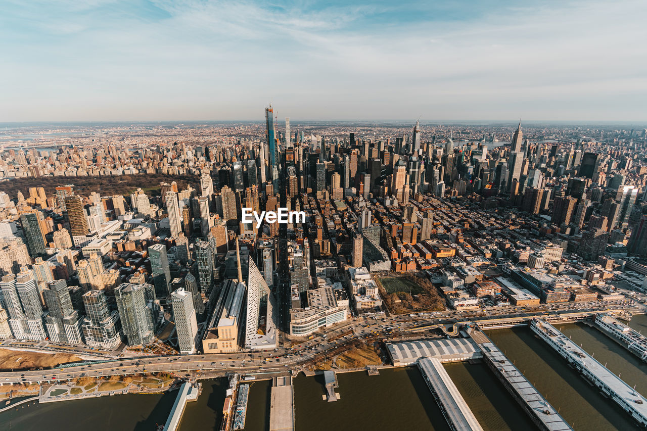 Aerial view of buildings against cloudy sky