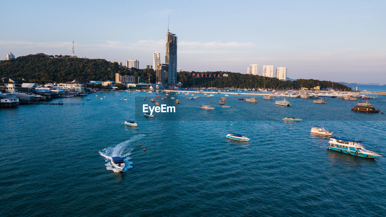 HIGH ANGLE VIEW OF BUILDINGS AND SEA AGAINST SKY