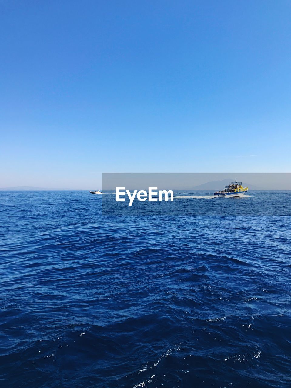 BOAT SAILING IN SEA AGAINST CLEAR SKY