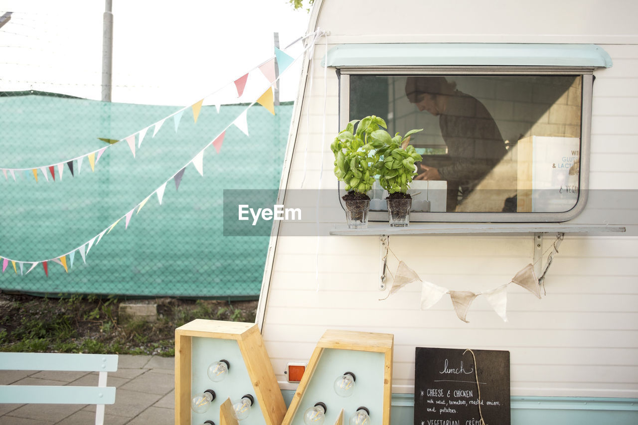 Male owner seen through glass window on food truck at street