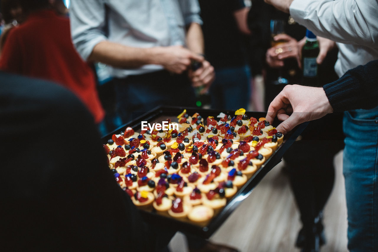 MIDSECTION OF PEOPLE HOLDING CAKE