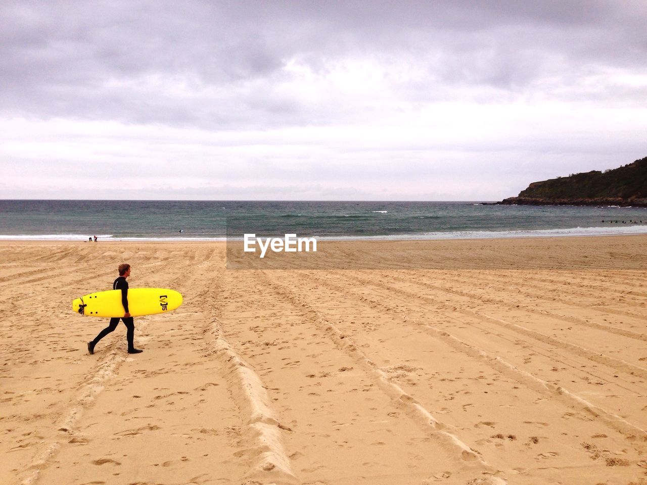 Surfer on beach against sky