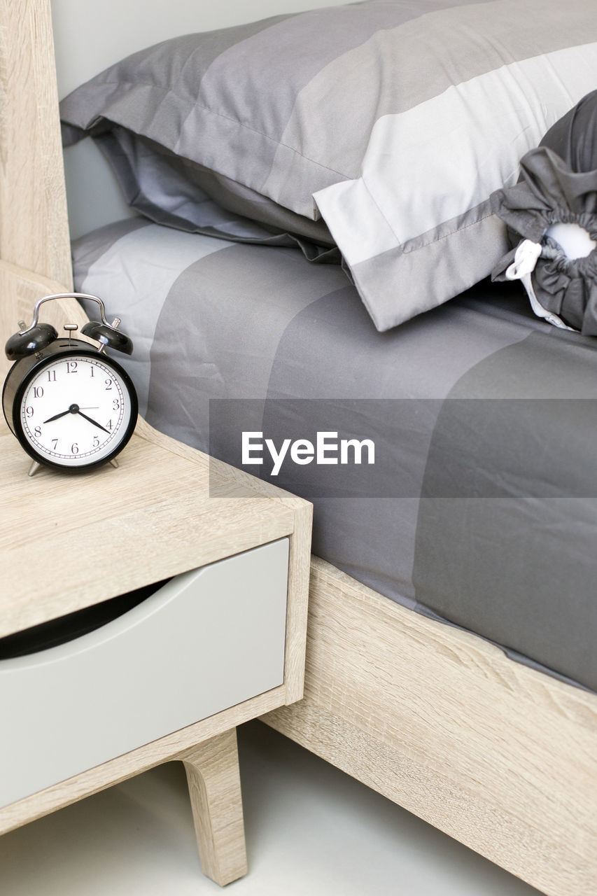 Alarm clock on table by bed at home