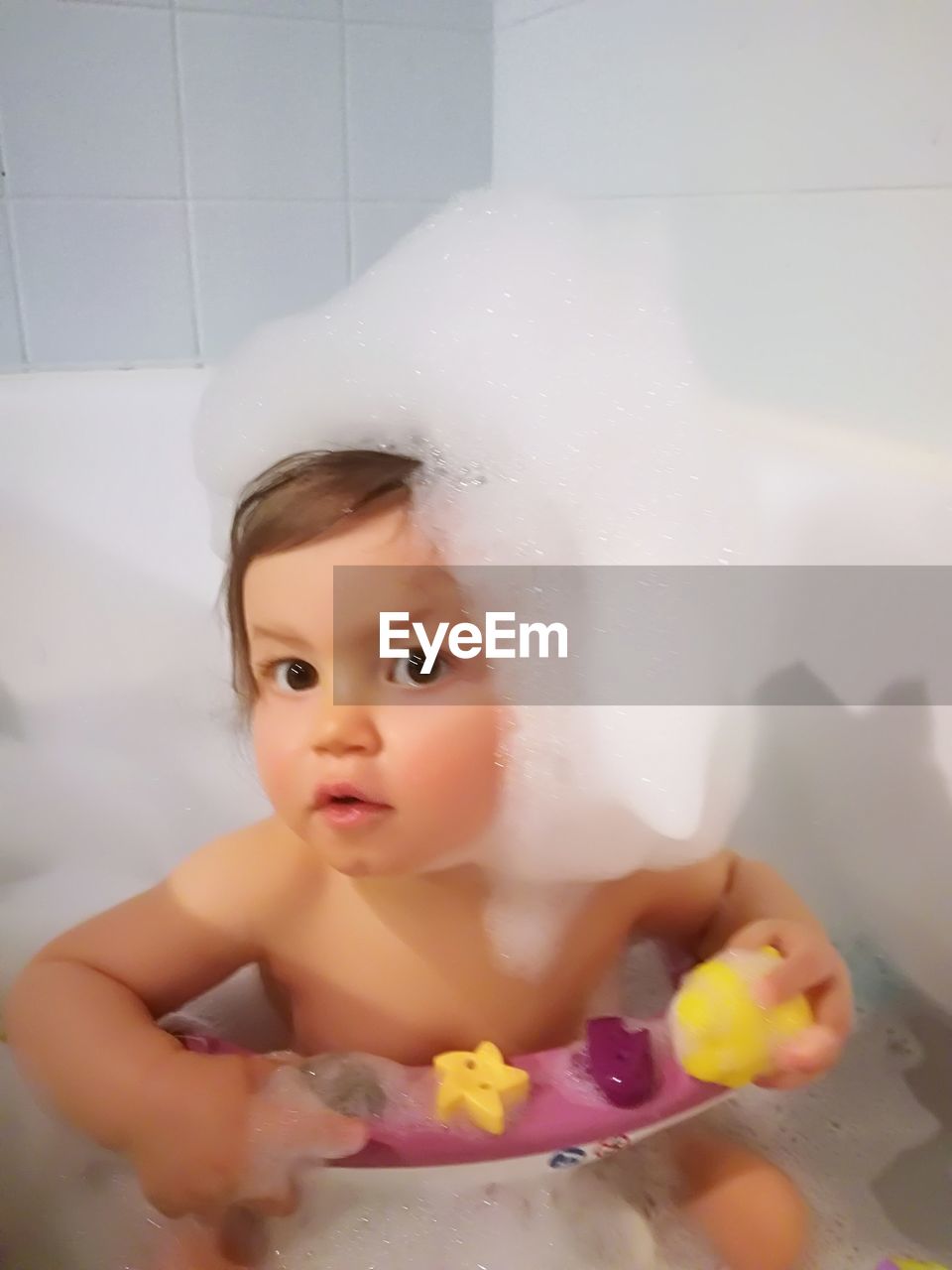 PORTRAIT OF CUTE BABY GIRL IN BATHTUB