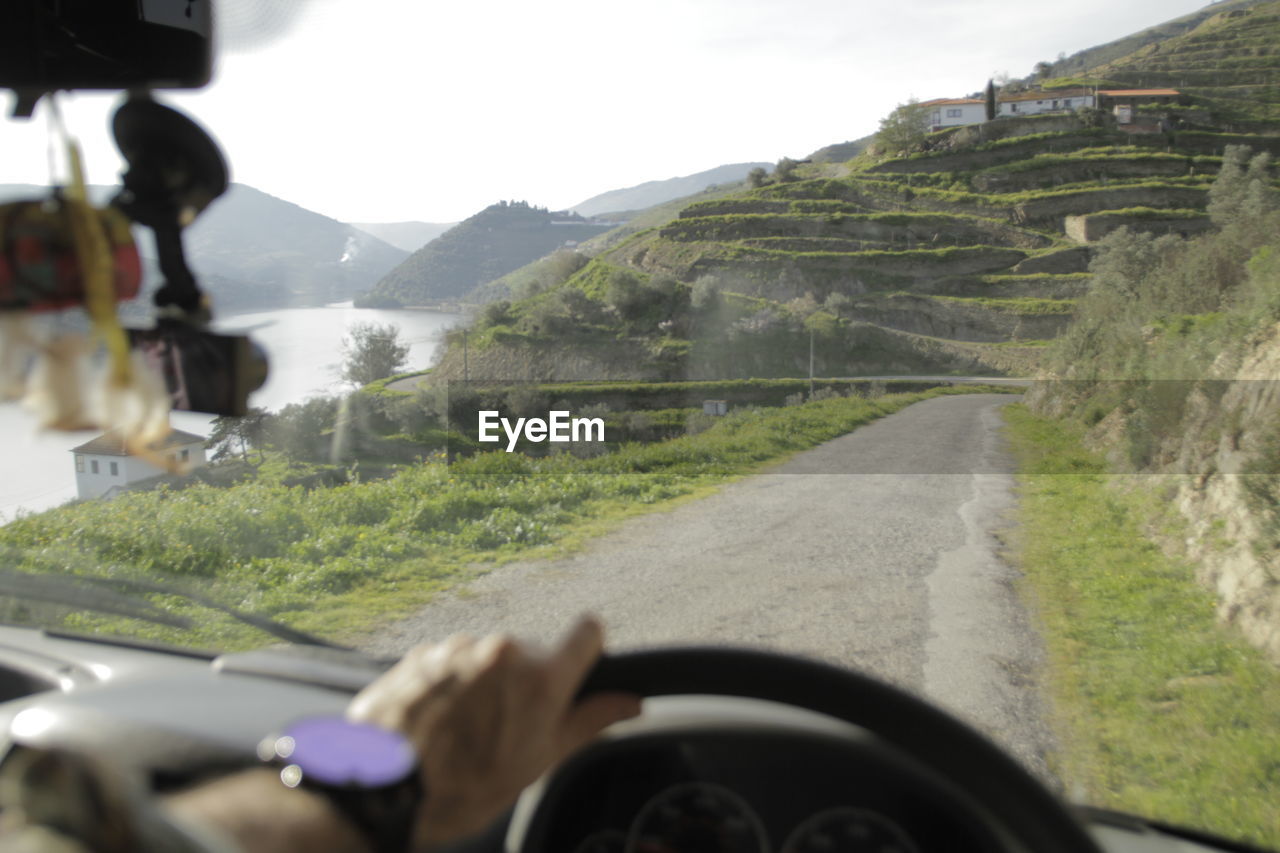 ROAD SEEN THROUGH WINDSHIELD OF CAR ON MOUNTAIN