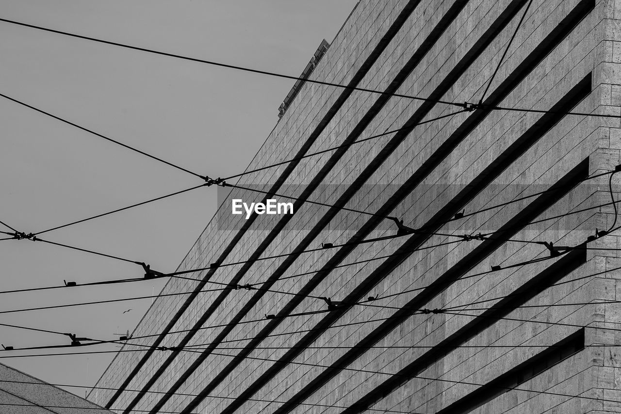 LOW ANGLE VIEW OF POWER LINES AGAINST CLEAR SKY