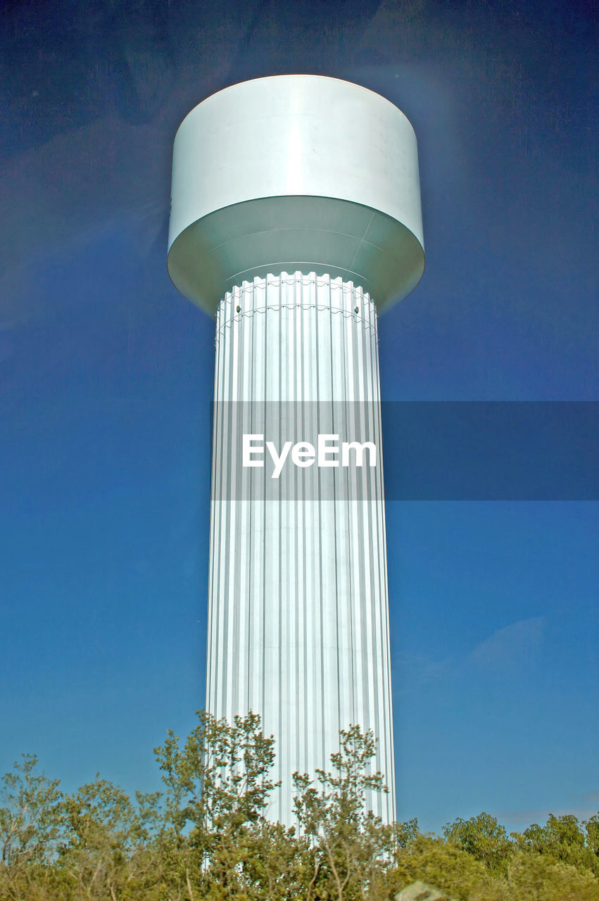 A white water tower with blue sky