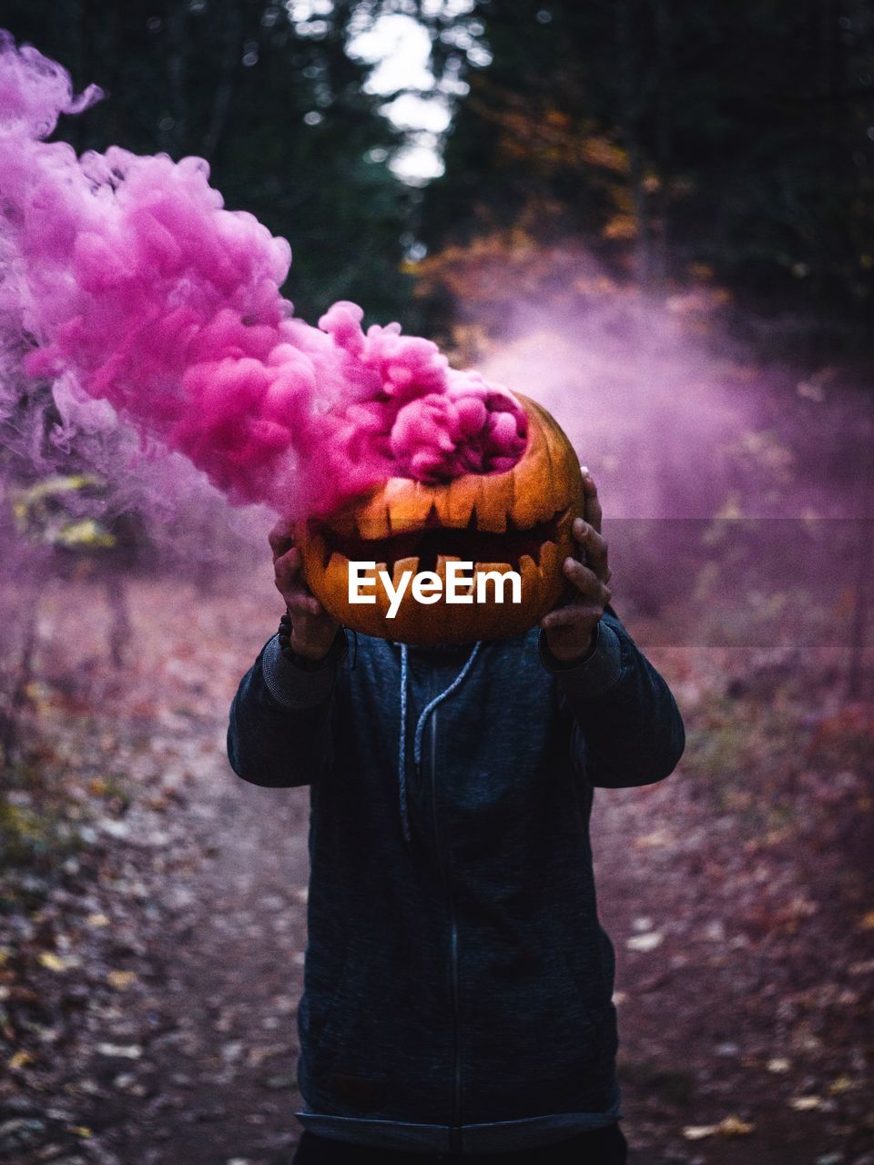 Person holding pumpkin emitting purple distress flare
