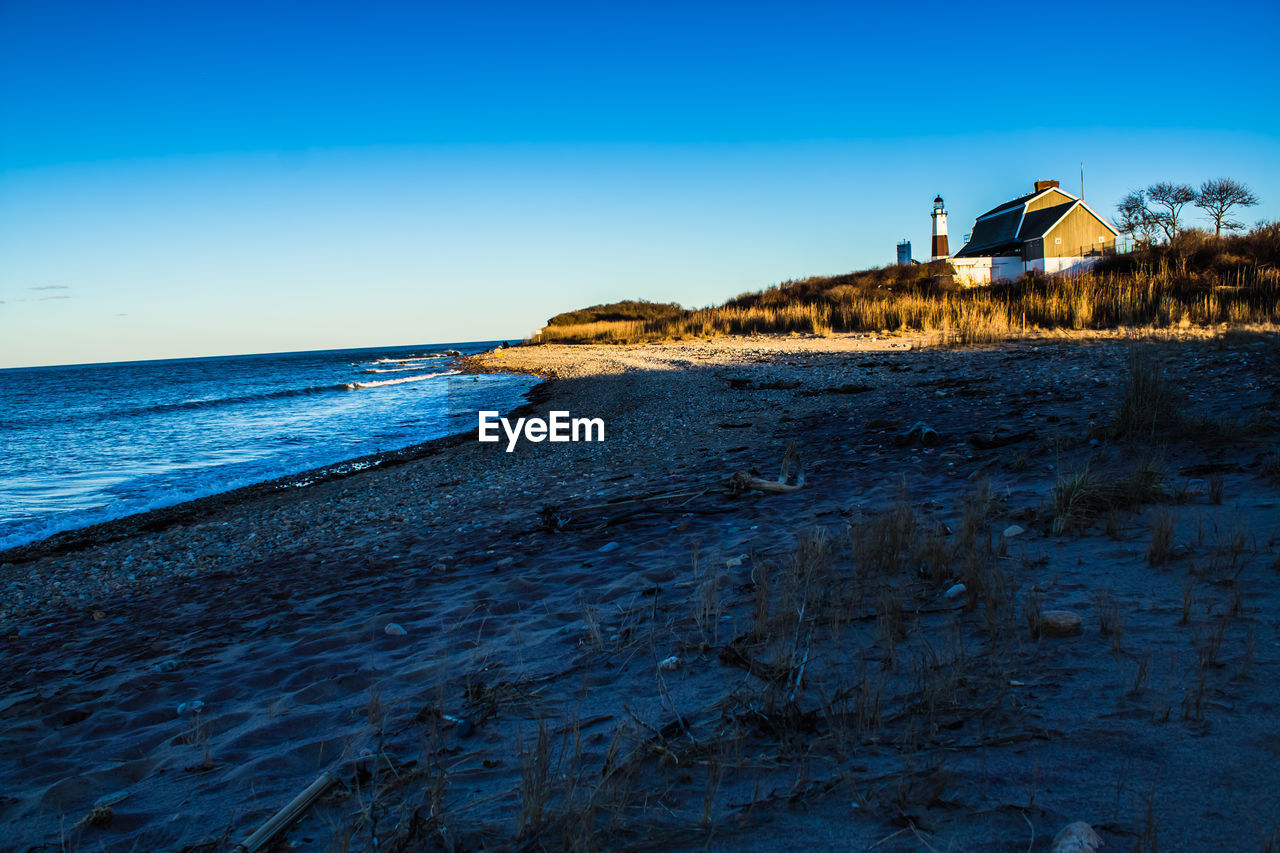 Scenic view of beach against clear blue sky