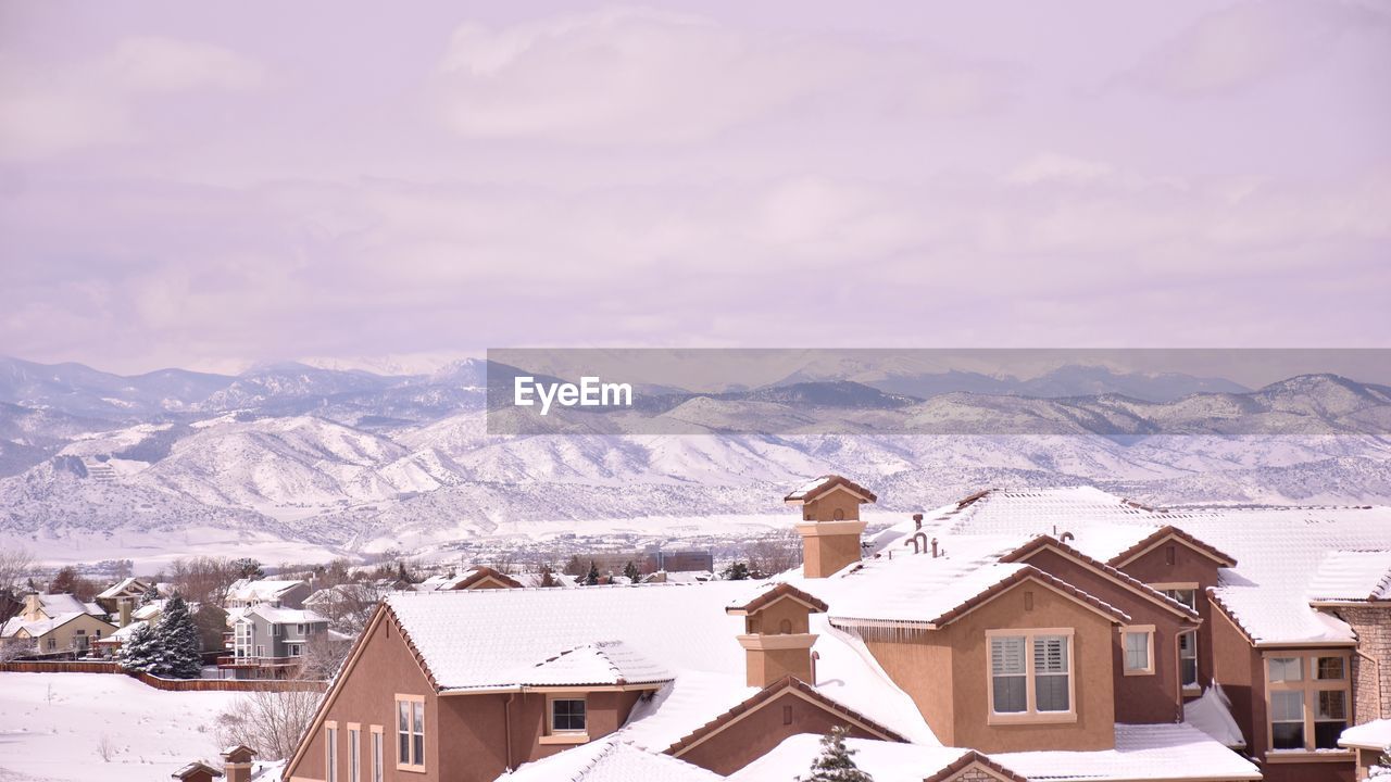 SNOW COVERED HOUSES AGAINST MOUNTAINS