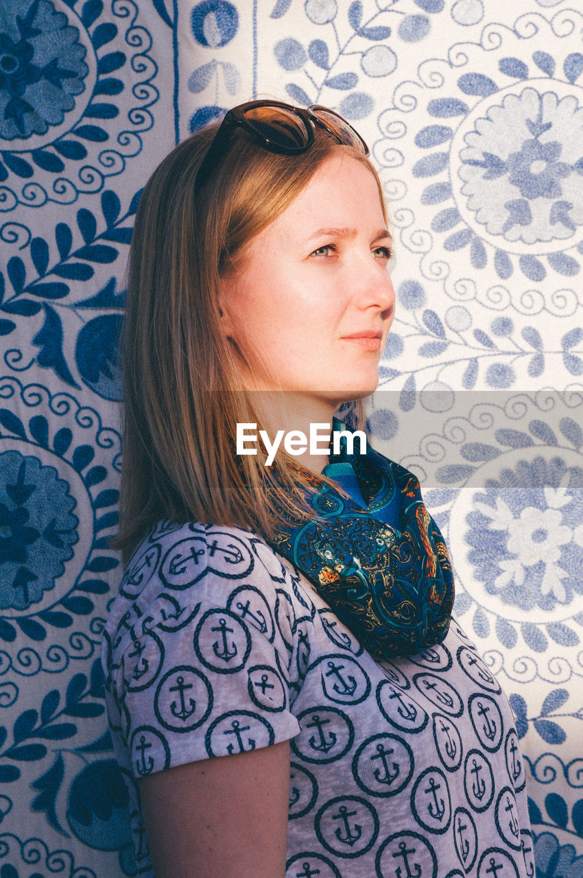 Portrait of a blonde girl against a blue mosaic background