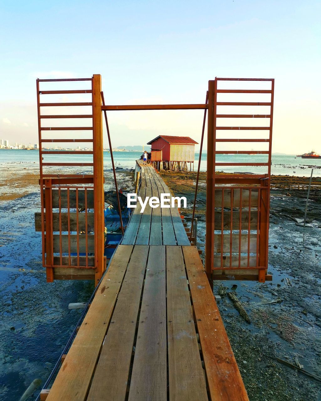 Pier on beach against sky