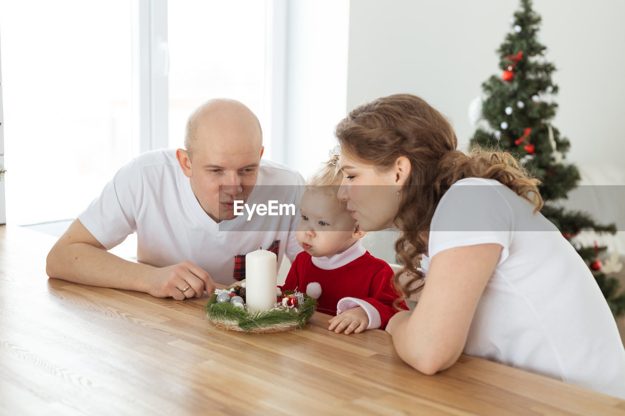 portrait of siblings sitting on table at home