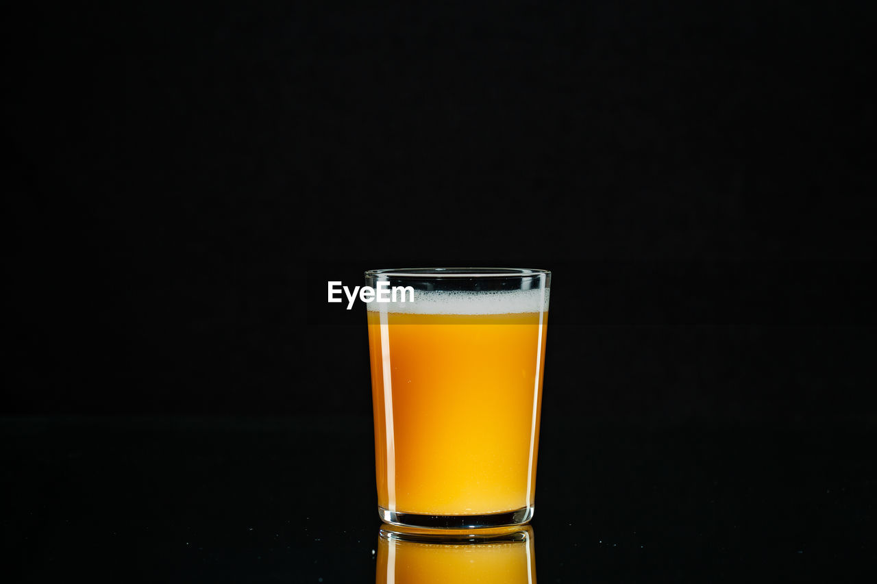 Close-up of beer glass against black background