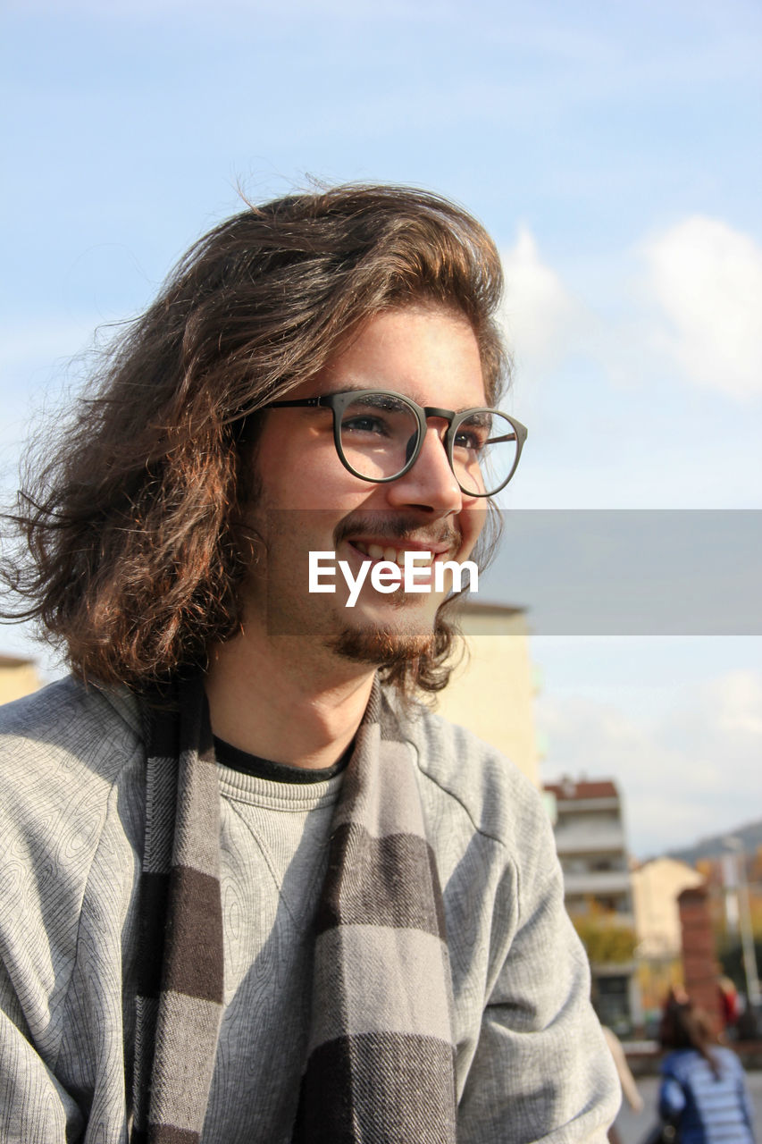 Close-up of smiling young man looking away